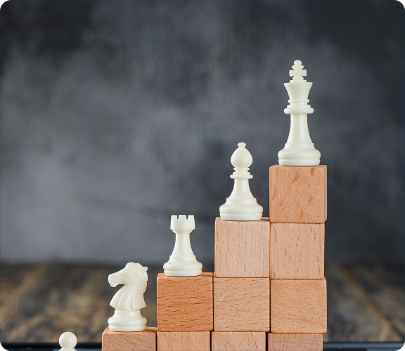 Chess pieces on rising blocks, symbolizing strategic growth and positioning.